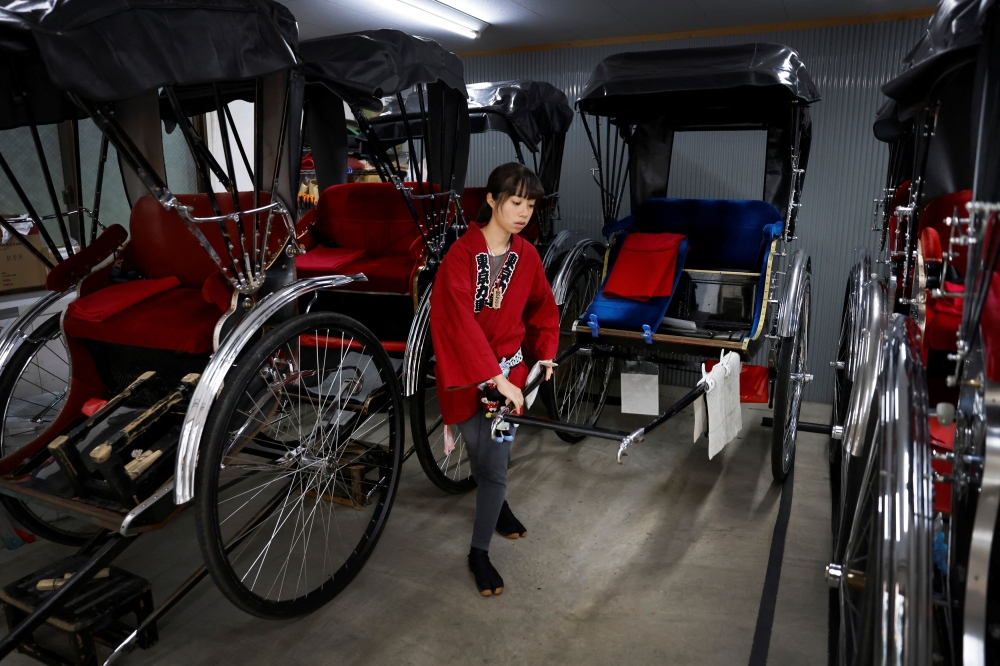 Rickshaw puller Yuka Akimoto, 21, prepares her rickshaw in a garage at the Asakusa district, Tokyo, Japan, August 22, 2023. — Reuters pic