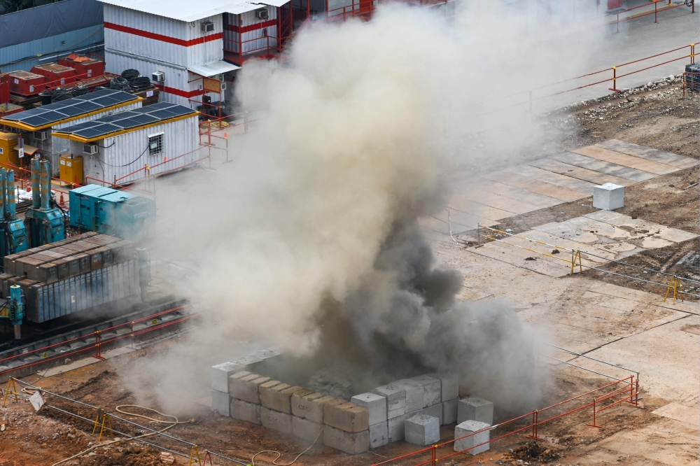 Smoke rises after a 100kg World War II-era aerial bomb is detonated at a construction site in Singapore on September 26, 2023. ― AFP pic