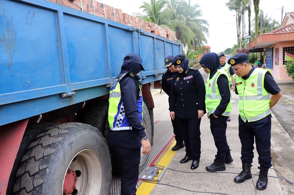Sarawak JPJ deputy director Noraini Mohd Nawi (third right) and others checking the weight of a lorry. — Borneo Post Online pic