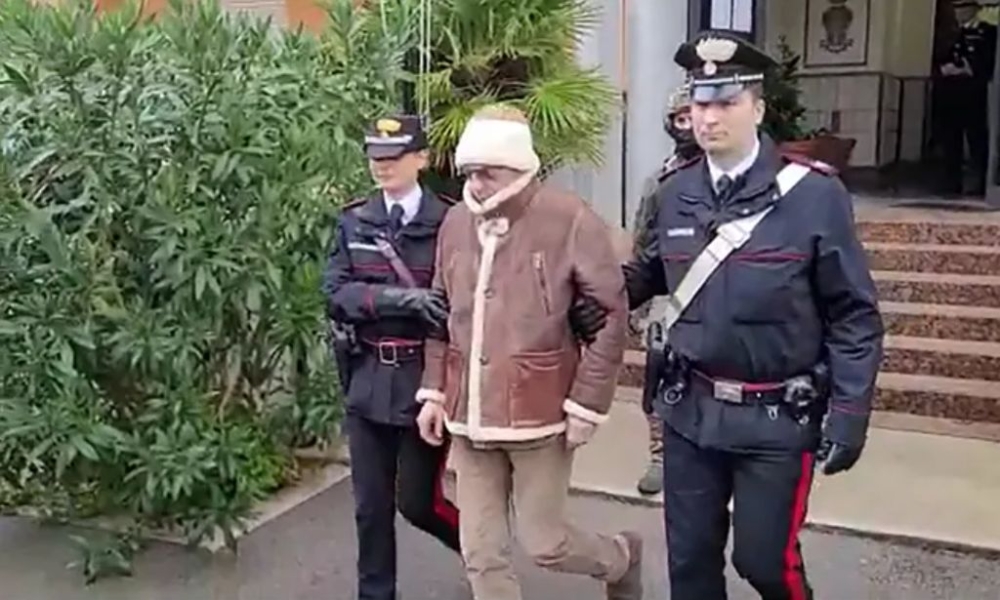 This handout video grab taken and released by the Italian Carabinieri Press Office on January 16, 2023 shows the transfer of Italy’s top wanted mafia boss, Matteo Messina Denaro (centre) from the Carabinieri police station of San Lorenzo in Palermo, to an undisclosed location. — Italian Carabinieri Press Office handout via AFP