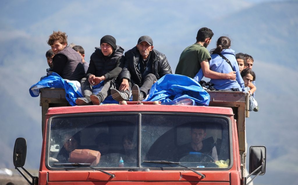 Refugees from Nagorno-Karabakh region ride in a truck upon their arrival at the border village of Kornidzor, Armenia, September 27, 2023. — Reuters pic