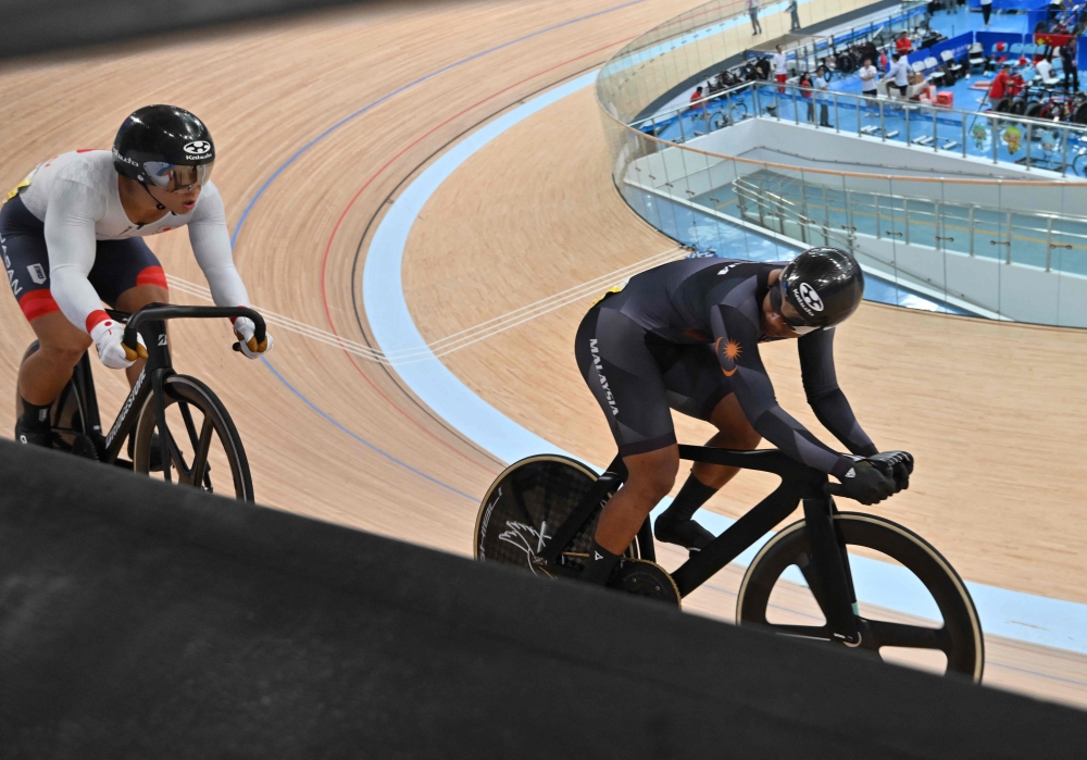 Malaysia’s Muhammad Shah Firdaus Sahrom (right) and Japan’s Shinji Nakano compete in the men’s sprint quarterfinal race 2 of the cycling track event during the 2022 Asian Games in Hangzhou in China’s eastern Zhejiang province on September 28, 2023. — AFP pic 