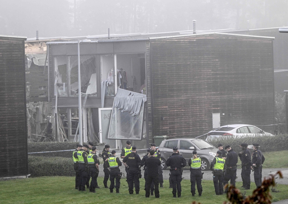 Policemen stand in front of a damaged building after a powerful explosion occurred in the early morning of September 28, 2023 in a housing area in Storvreta outside Uppsala. — AFP pic