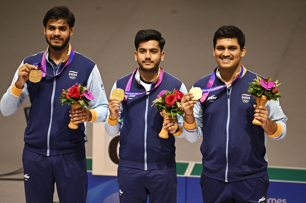 Gold medallist India's Divyansh Singh Panwar, Aishwary Pratap Singh Tomar and Rudrankksh Patil celebrate on the podium after winning the men's 10m air rifle team final. — AFP pic