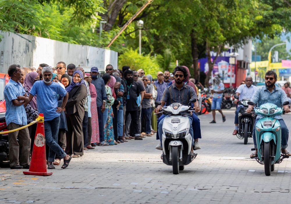 People stand in a line to cast their vote outside a polling station during the second round of a presidential election in Male, Maldives September 30, 2023. ― Reuters pic