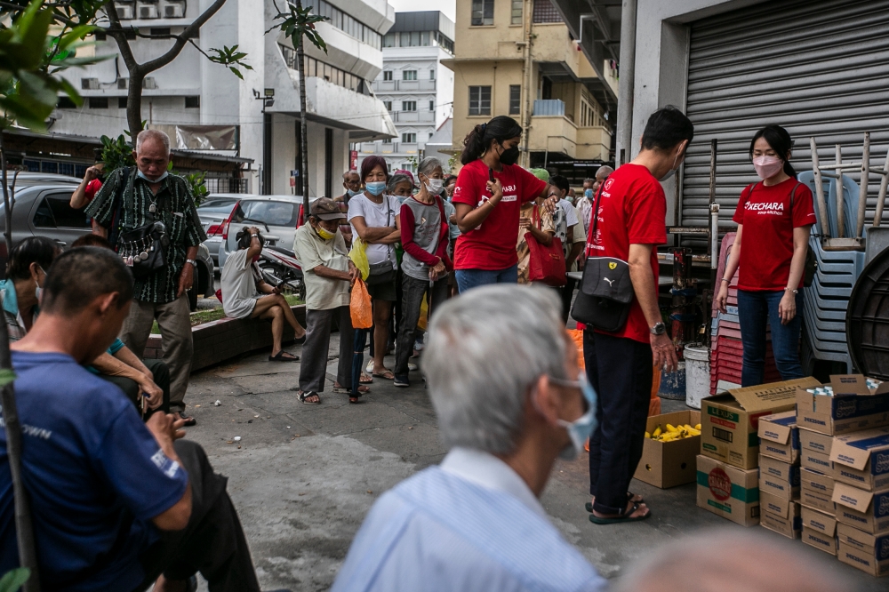 Kechara’s volunteers handing out food and drinks as well as assisting patrons to get their health check-up at their mobile clinic in Pudu, Kuala Lumpur June 25, 2022. — Picture by Hari Anggara