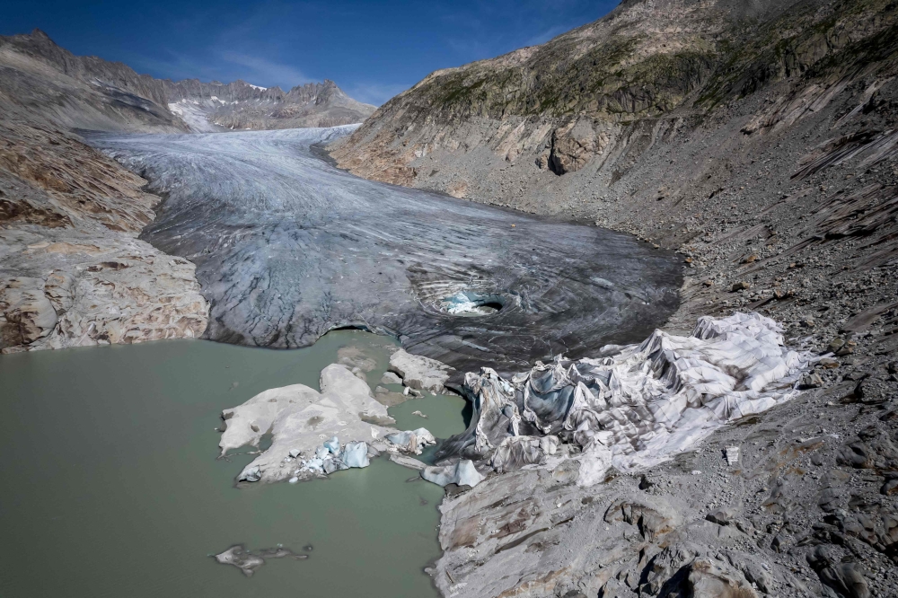 An aerial photograph taken on August 24, 2023 above Gletsch, in the Swiss Alps shows insulating foam covering a part of the Rhone Glacier to prevent it from melting, and exposing small glacial lakes on its surface due to the ice melting. — AFP pic
