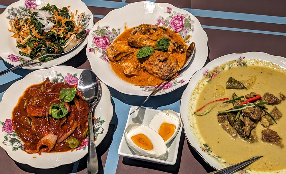 From top left: Kerabu Pucuk Paku & Taugeh, Sambal Tumis Udang Petai, Ayam Rose and Daging Salai Gulai Lemak at Chinta. — Pictures by Ethan Lau