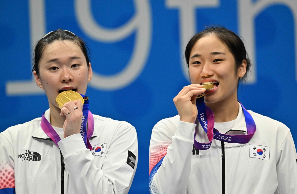 Gold medallists South Korea's An Se-young (right) and Kim Ga-eun celebrate during the medals ceremony for the women's team badminton event at the 2022 Asian Games in Hangzhou on October 1, 2023. — AFP pic