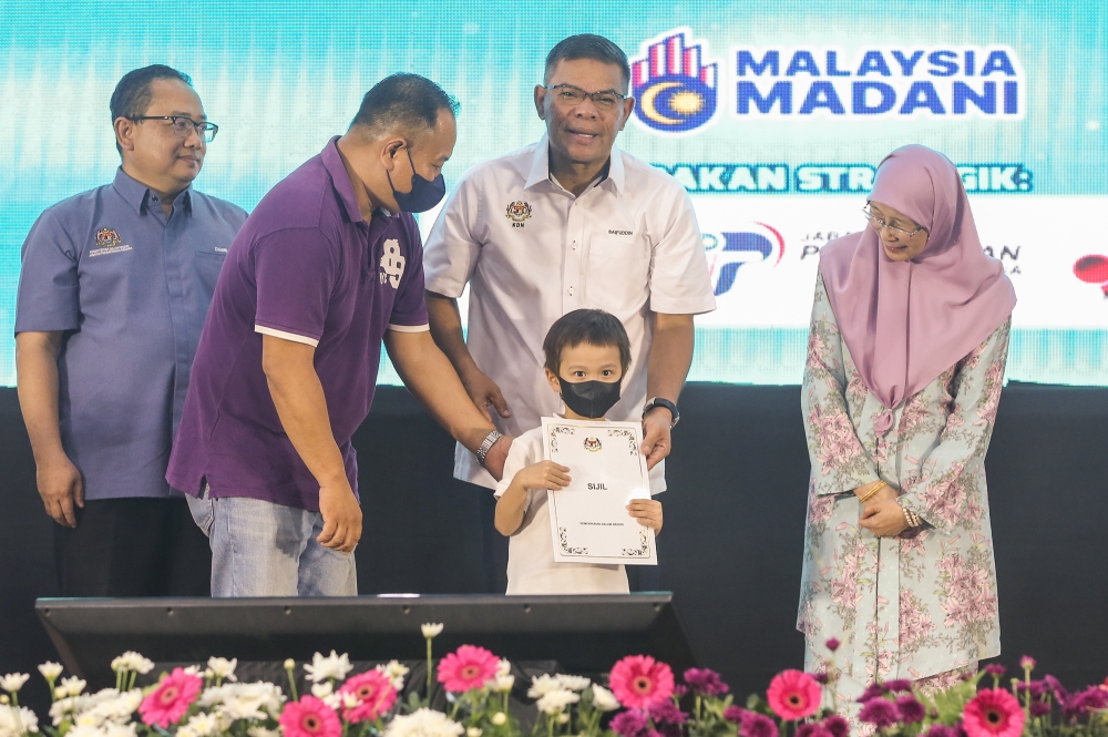 Home Minister Datuk Seri Saifuddin Nasution Ismail (centre) hands over citizenship application approval letters to recipients during the ministry’s Madani programme at Bandar Tun Razak Sport Complex in Kuala Lumpur October 1, 2023. — Picture by Yusof Mat Isa 