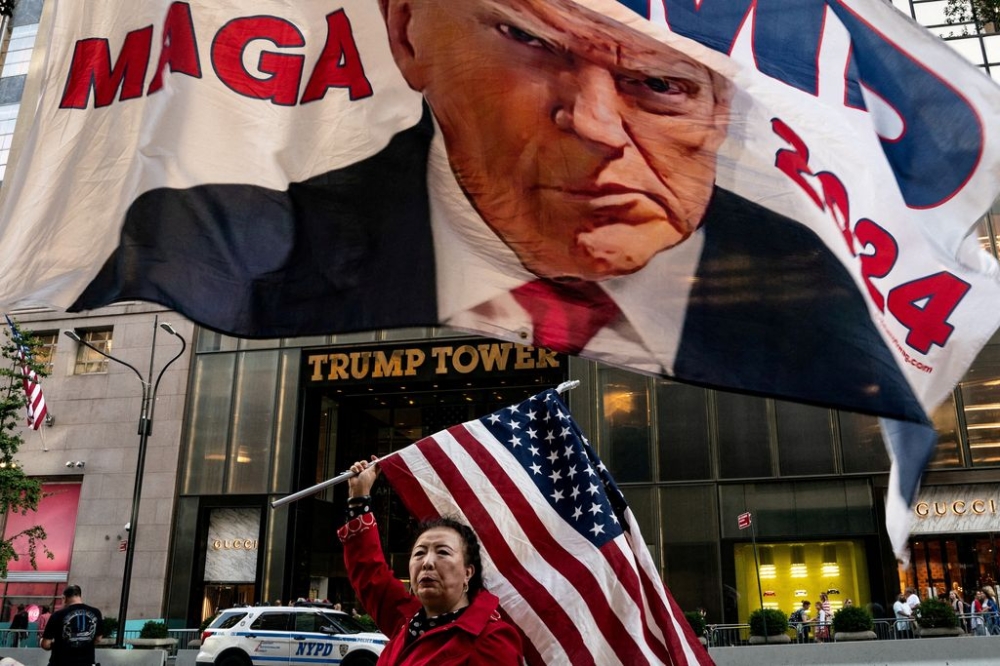 A supporter of former US President Donald Trump holds up a US national flag at Trump Tower in New York City, US, October 1, 2023. — Reuters pic