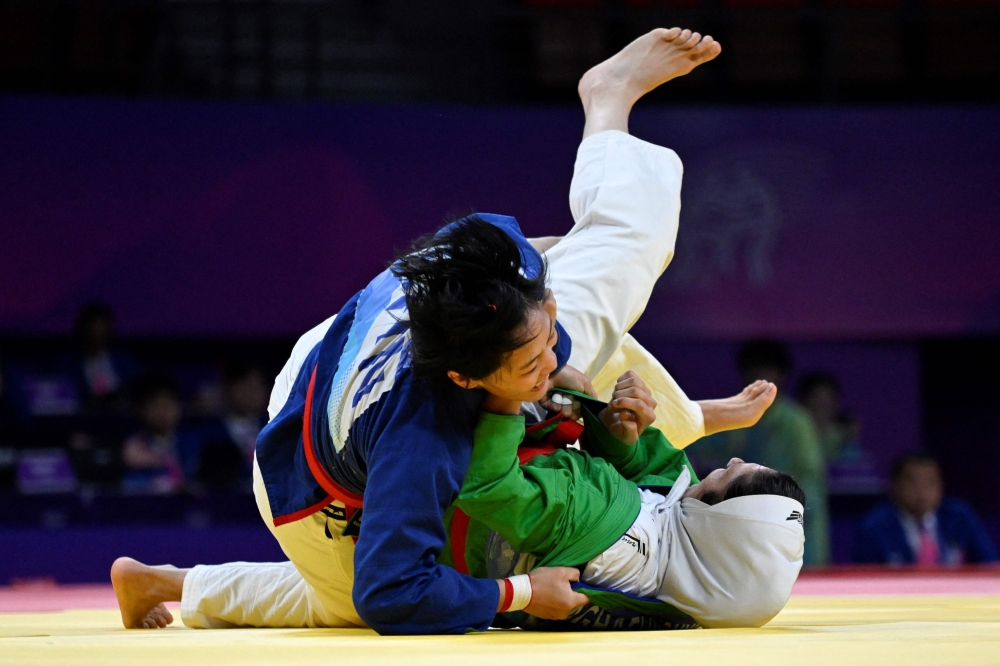China's Yu Dan (left) competes agaisnt Iran's Donya Aghaei in the women's 70 kg finals kurash event during the Hangzhou 2022 Asian Games in Hangzhou, in China's eastern Zhejiang province October 1, 2023. — AFP pic