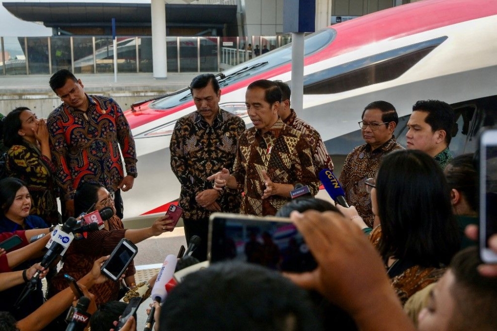 Indonesian President Joko Widodo (centre) accompany by Coordinating Minister for Maritime Affairs and Investment Luhut Binsar Pandjaitan (third left), State Secretary Pratikno (second right) and Minister of State-Owned Enterprises Erick Thohir (right), answers journalists questions during the inauguration of the Jakarta-Bandung high-speed train named 'Whoosh' at Padalarang station in Padalarang, West Java on October 2, 2023. — AFP pic