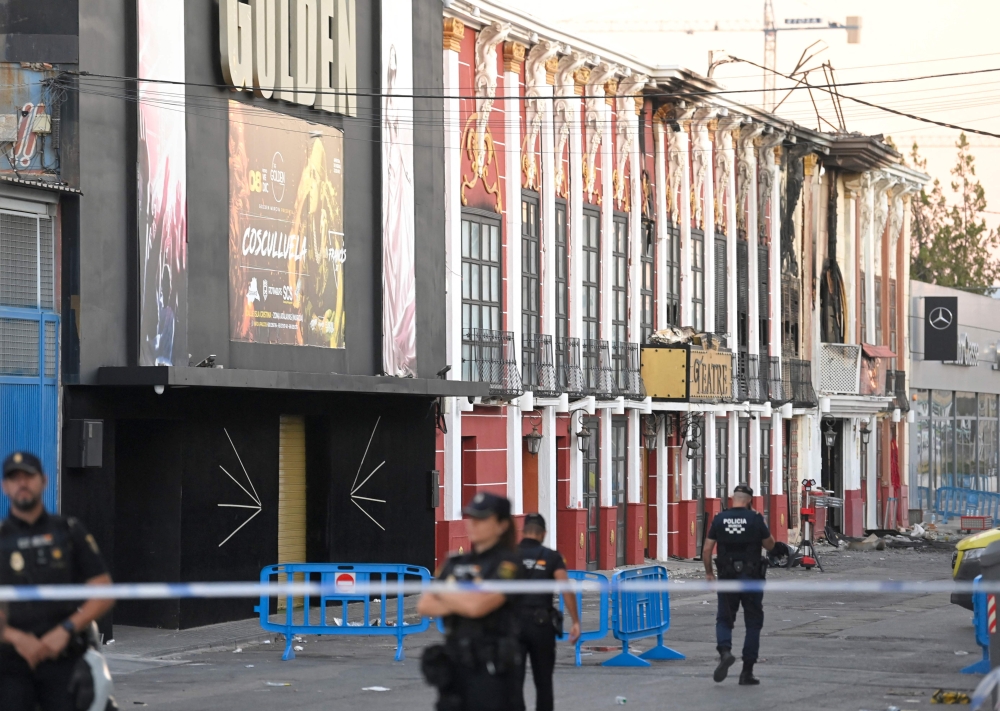 This picture taken on October 2, 2023 shows police officers blocking access after a fire in a nightclub that at least killed thirteen people at a nightclub in Murcia. — AFP pic