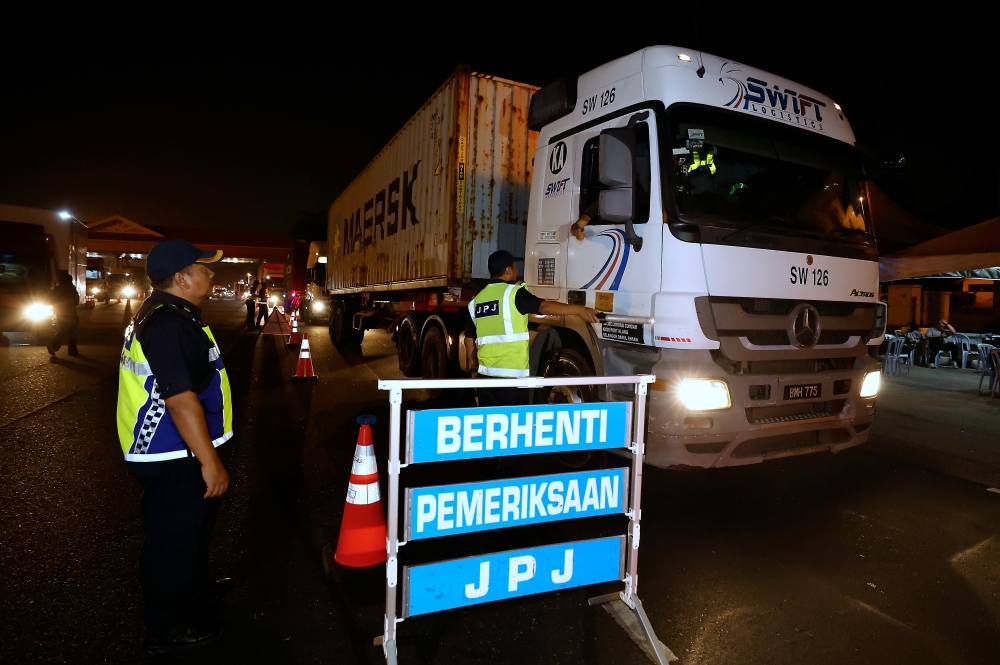 JPJ personnel during an operation at the Kemuning toll plaza of the Kesas highway, October 2, 2023. — Bernama pic 
