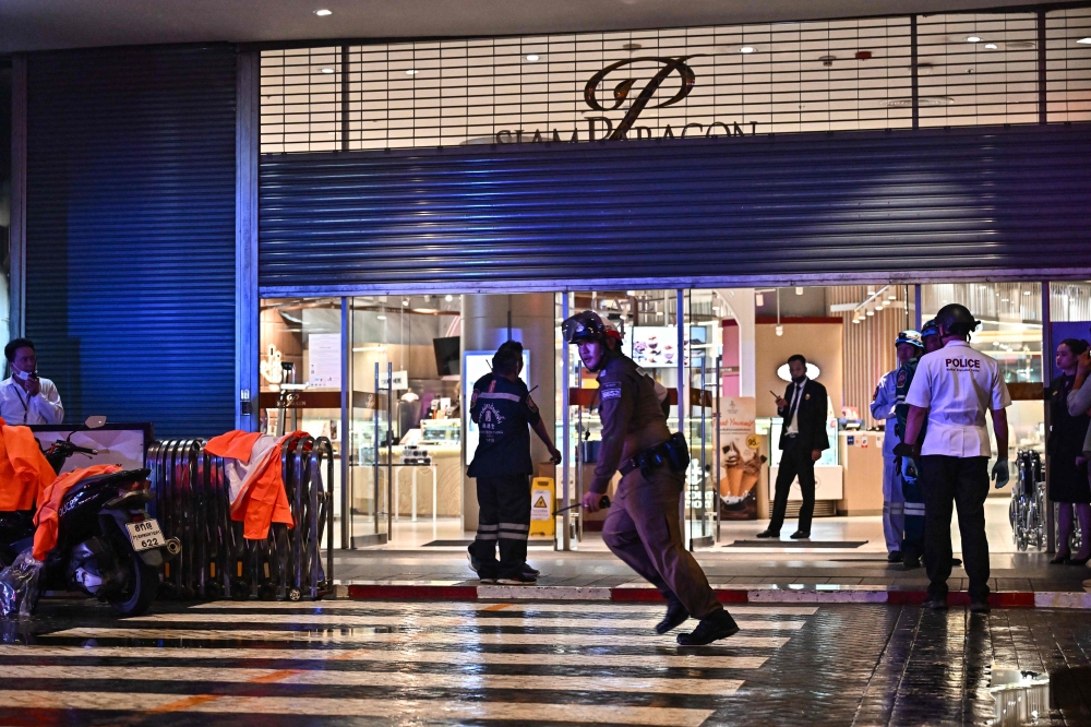 Police officers and rescue workers stand outside Siam Paragon shopping centre in Bangkok on October 3, 2023, following a shooting incident in the mall. — AFP pic 