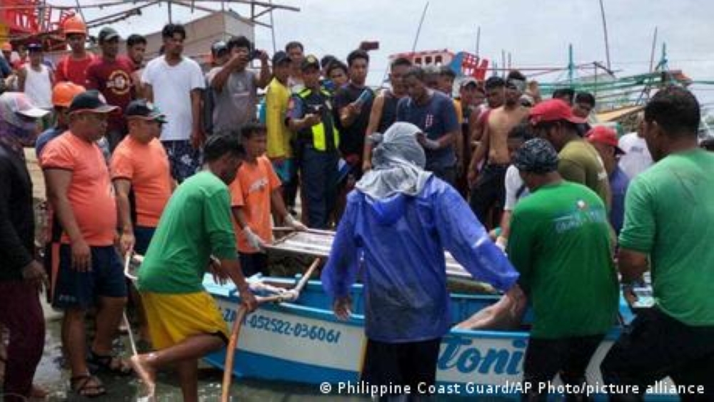 Rescuers carry the body of one of the victims as it arrives at a port in Infanta. — Philippine Coast Guard/AP Photo/picture alliance via DW