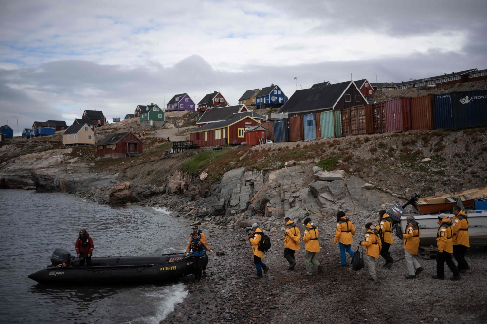 Tourists leave Ittoqqortoormiit after visiting the village, on August 20, 2023, to be transported to their tourist charter vessel 