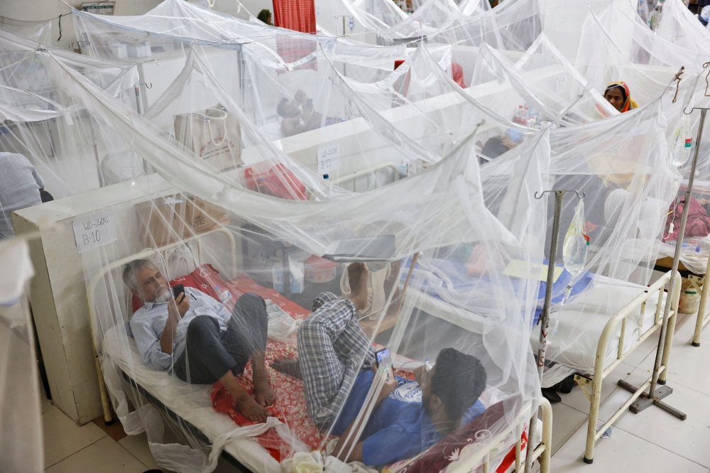 Patients stay under mosquito nets as they receive treatment at the Shaheed Suhrawardy Medical College and Hospital in Dhaka, Bangladesh. — Reuters pic