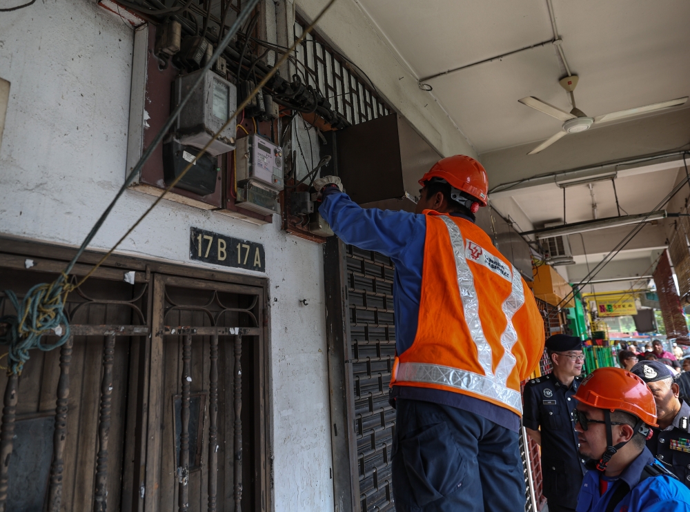 TNB personnel disconnect the electricity supply of a premise selling public lottery without a licence under the pretext of legal business in Ipoh, October 6, 2023. — Bernama pic