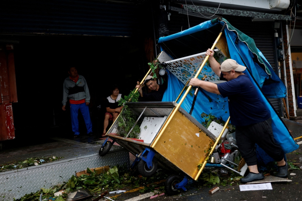 Workers lift up a turned-over food cart after Typhoon Koinu passed the southern tip of Taiwan, in Kenting, Taiwan October 5, 2023. — Reuters pic