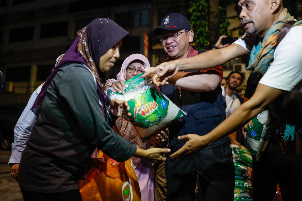 Minister in the Prime Minister’s Department (Religious Affairs) Datuk Mohd Na’im Mokhtar distributes aid packages at the 'Jejak Gelandangan' (Tracking the Homeless) programme at Lorong Haji Taib in Kuala Lumpur October 5, 2023. — Bernama pic