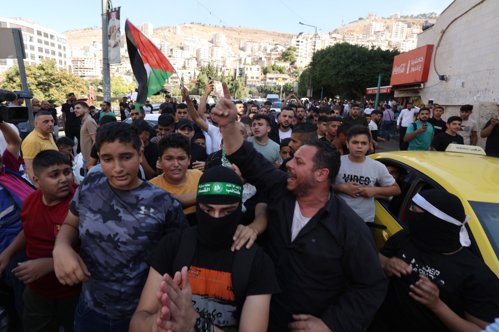 Palestinians in the West Bank city of Nablus celebrate on October 7, 2023, after fighters from the Gaza Strip infiltrated Israel, a major escalation in the Israeli-Palestinian conflict. — AFP pic