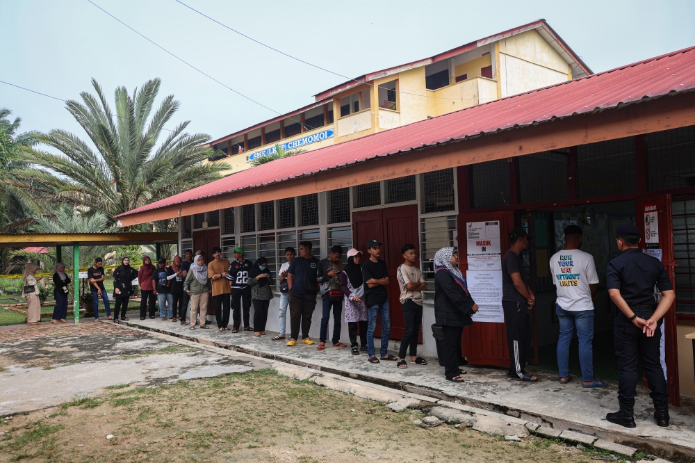Voters wait for their turn to cast their ballot at a voting centre in SMK Felda Chemomoi during the Pelangai by-election in Bentong October 7, 2023. — Bernama pic