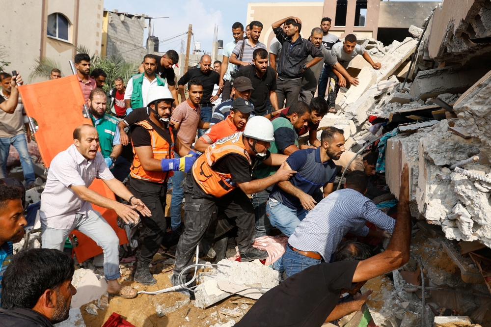 Palestinians search for casualties under the rubble of a house destroyed in Israeli strikes in Khan Younis, in the southern Gaza Strip. — Reuters pic
