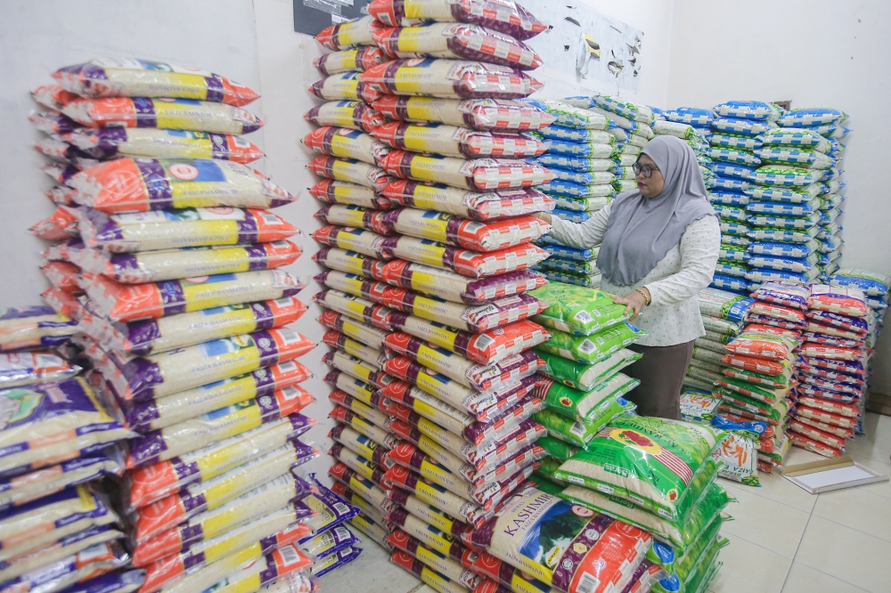 Staff of rice distributor Pemborong Manjoi stacking packets of rice at their Manjoi, Ipoh shop. — Picture by Farhan Najib