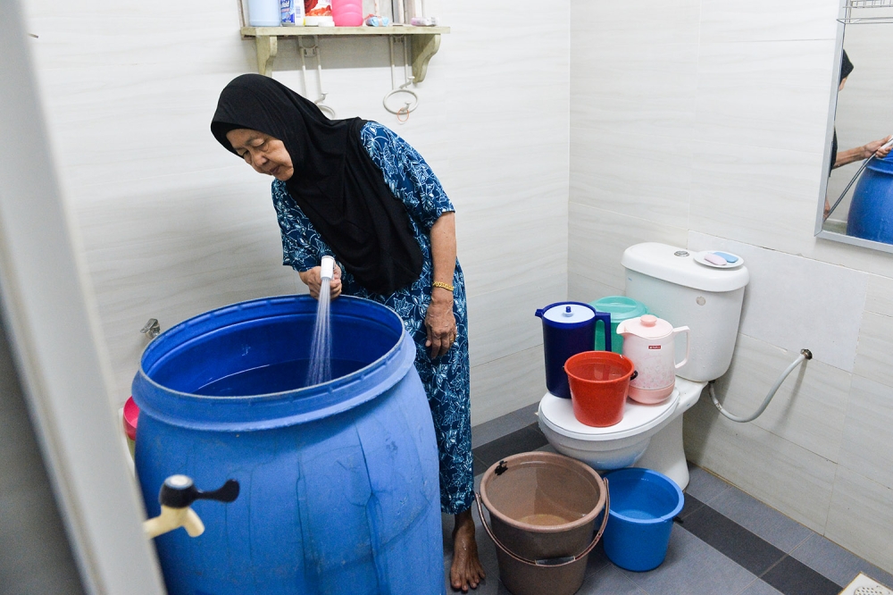 Housewife,Kamisah filling water in a plastic container in anticipation of a water cut in several areas throughout the Klang Valley in Selangor, October 10, 2023. — Picture by Miera Zulyana