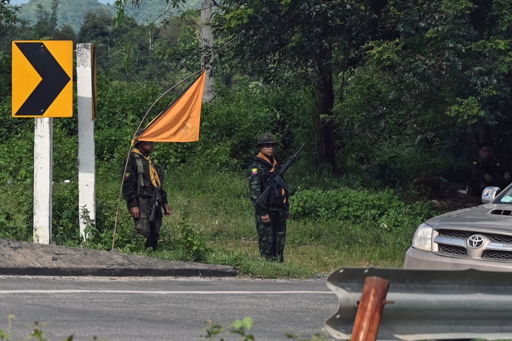 This photo taken on September 24, 2023 shows members of the Karen state Border Guard Forces (BGF) standing guard on the Yangon-Myawaddy section of the Asia Highway road near Kawkareik township. — AFP pic