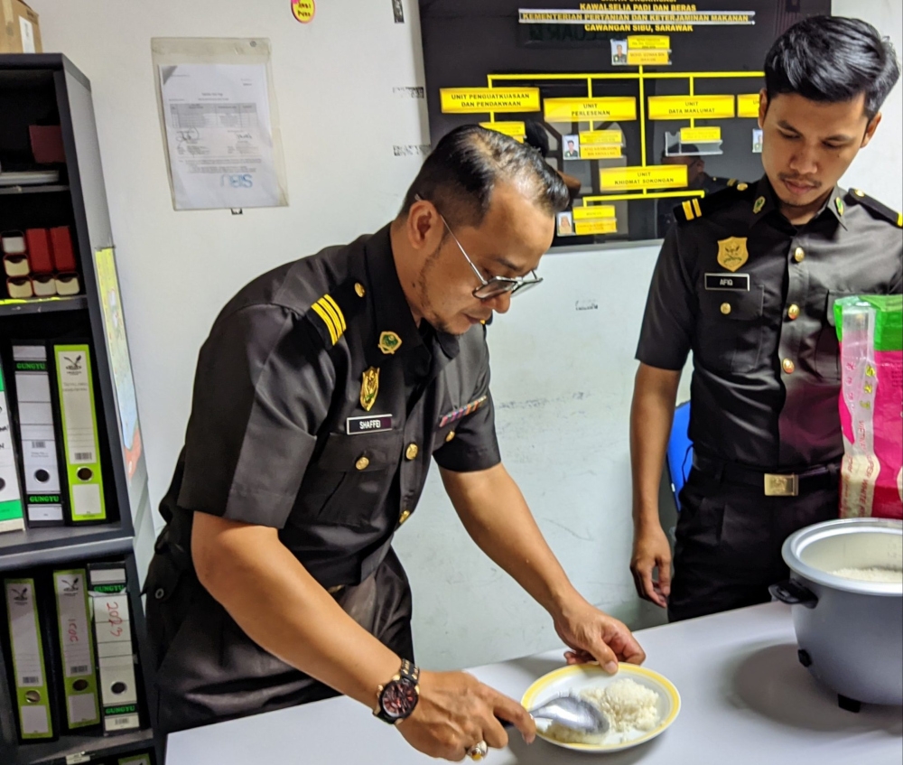 (From left) KPB Sibu senior assistant enforcement officer Mohd Shaffei Muhamad and assistant enforcement officer Afiq Aisamuddin run an analysis on a rice sample. — Borneo Post pic 