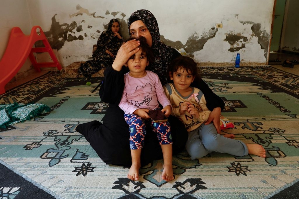 Palestinian woman Samah Abu Latifa, who fled her home amid Israeli strikes, shelters with her family in a kindergarten, in Khan Younis in the southern Gaza Strip October 10, 2023. — Reuters pic
