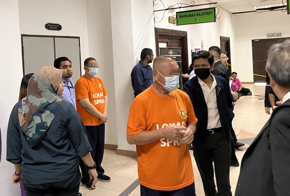 Two of the suspects are seen at the Kuching Court Complex after proceedings, October 11, 2023. — Borneo Post pic 