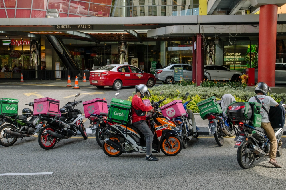 Motorcycles of various food delivery service riders outside a mall in Kuala Lumpur. — FilepPicture by Firdaus Latif