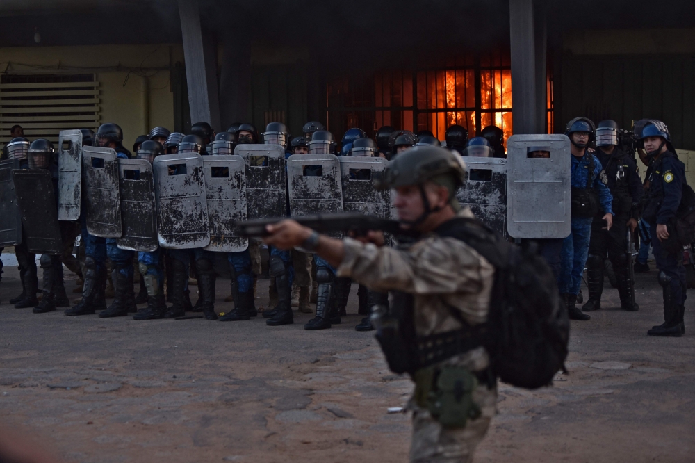 Hundreds of inmates set alight mattresses and lobbed rocks at officers from the roof of the overcrowded Tacumbu jail during the riot, which began Tuesday and ended yesterday after negotiations with authorities. — AFP pic