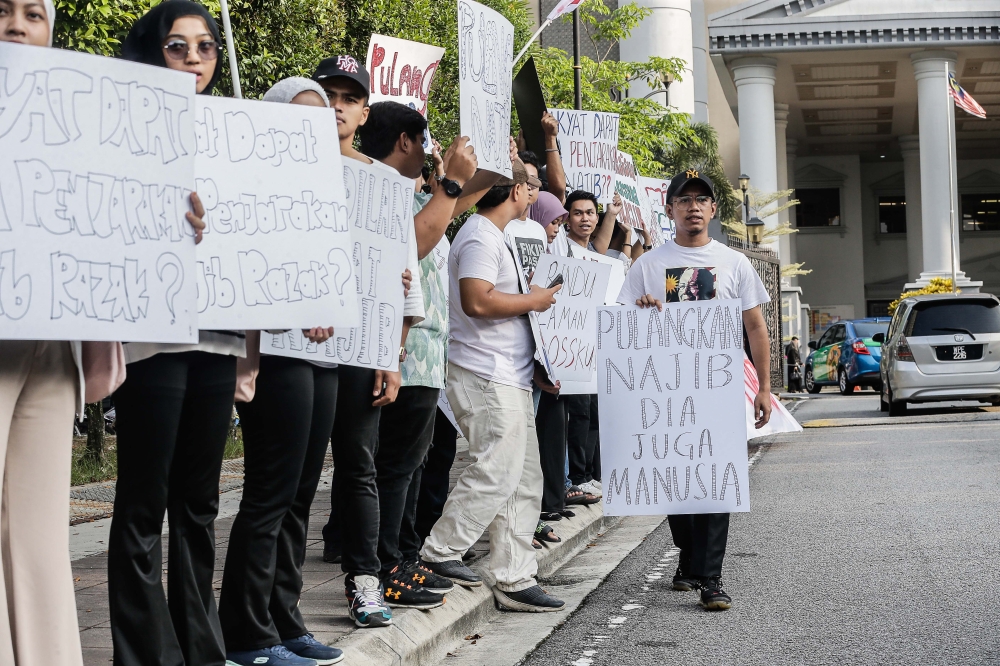 Students from the Gerakan Pulangkan Najib group hold placards supporting former prime minister Datuk Seri Najib Razak are seen outside the Kuala Lumpur Court Complex. ― Picture by Sayuti Zainudin