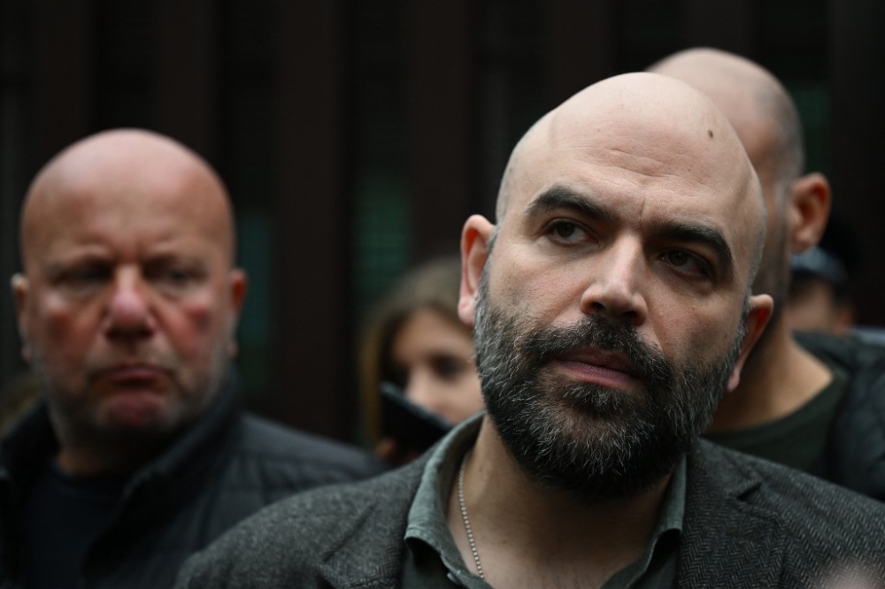 Italian writer Roberto Saviano (right) addresses the media as he leaves on November 15, 2022 the City of Justice (Citta Giudiziaria) in Rome, following a hearing in a defamation lawsuit from Italy’s current prime minister. — AFP pic