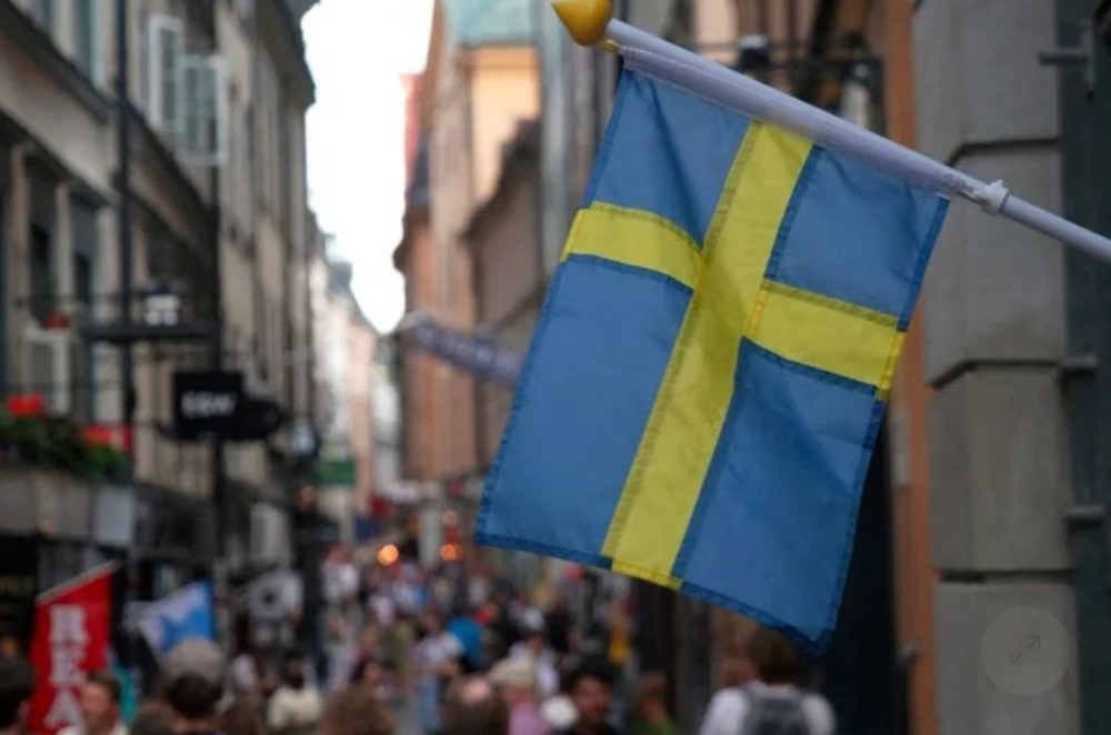 File photo shows a Swedish flag hanging outside a store in the old town of Stockholm. — Reuters pic