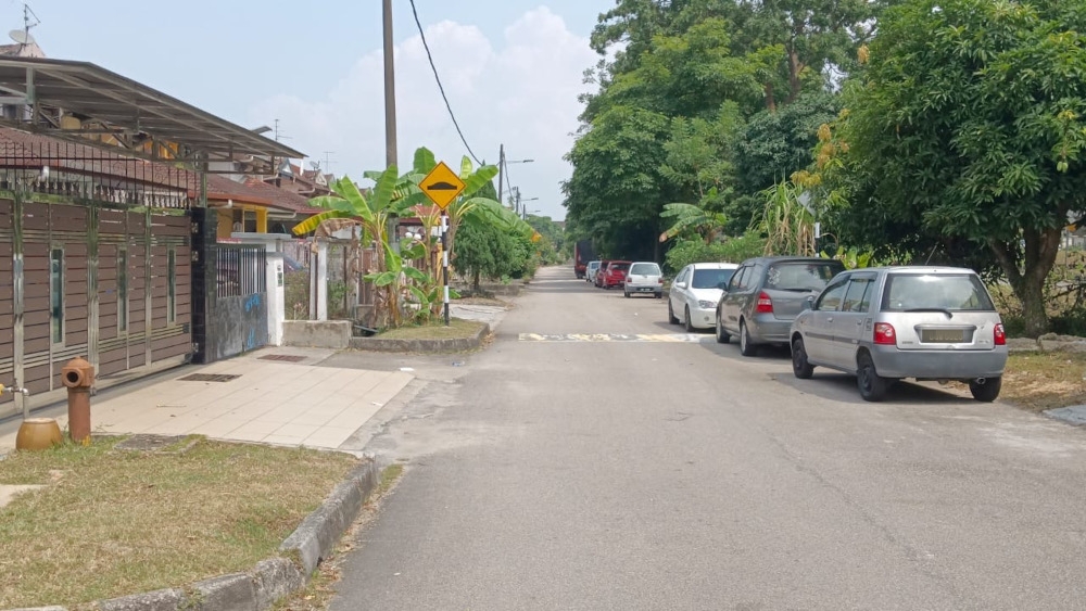 A typical scene in Taman Pasir Putih in Pasir Gudang where a majority of residents park their cars in front of the entrance to their home due to a lack of space. — Picture by Ben Tan