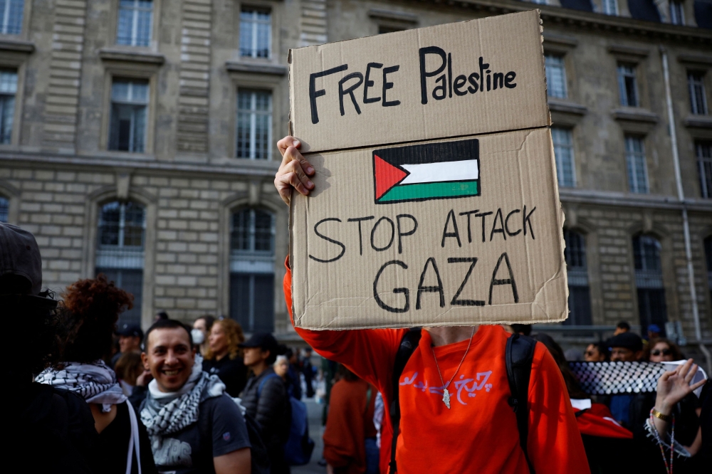 A protestor holds a placard reading 