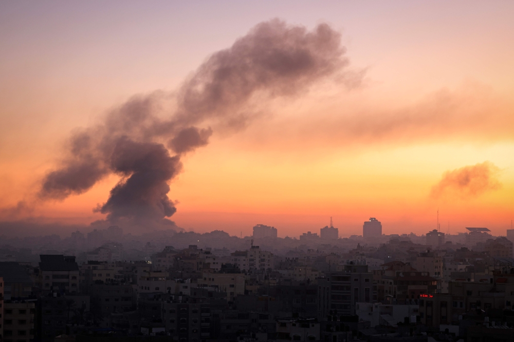Fire and smoke rise above buildings in Gaza City during an Israeli air strike, on October 13, 2023, as raging battles between Israel and the Hamas movement continue for the sixth consecutive day. — AFP pic