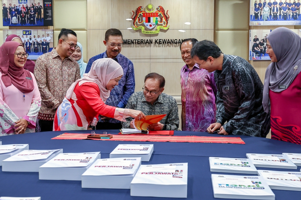 Prime Minister Datuk Seri Anwar Ibrahim signs off on the Budget 2024 documents in Putrajaya October 12, 2023. — Bernama pic