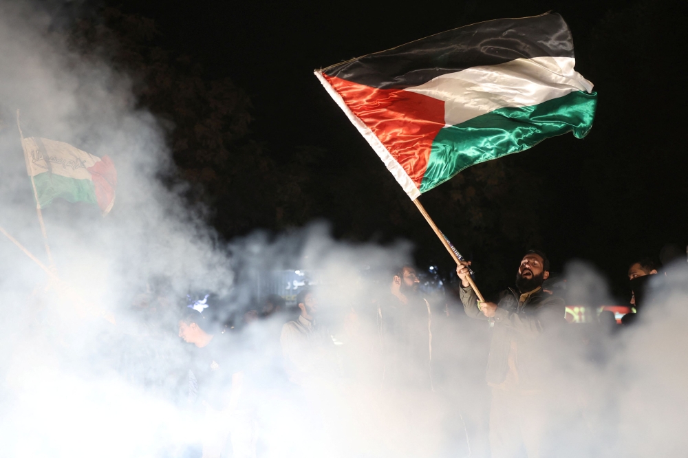 An Iranian man holds a Palestinian flag during a gathering in support of Palestinians, in Tehran, Iran, October 7, 2023. — Majid Asgaripour/WANA (West Asia News Agency) Reuters pic