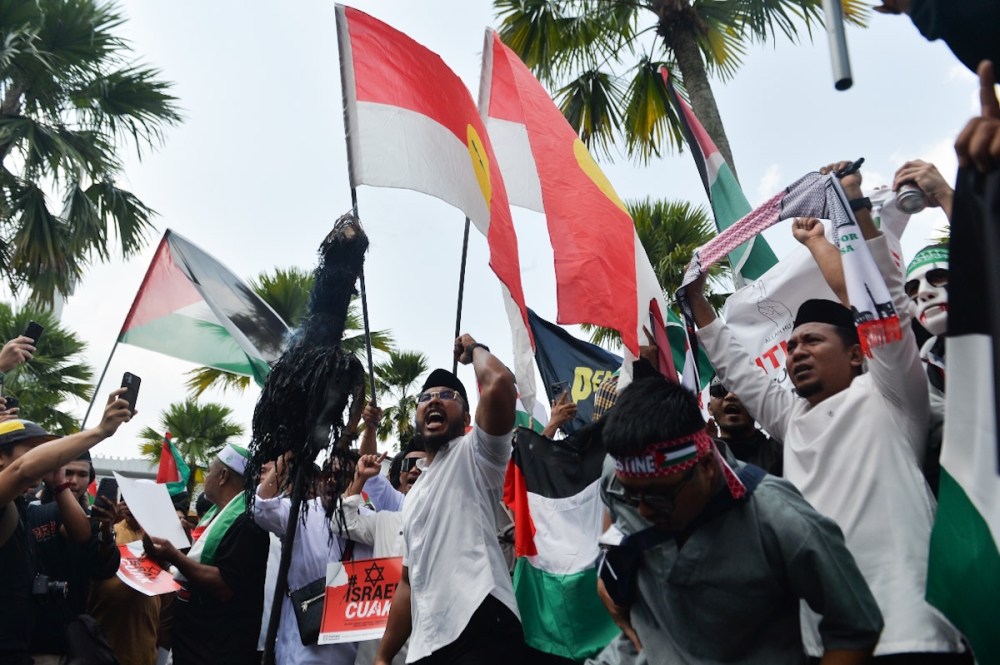 People wave flags as they gather during the 'Free Palestine' rally at Masjid Negara in Kuala Lumpur October 13,2023. 