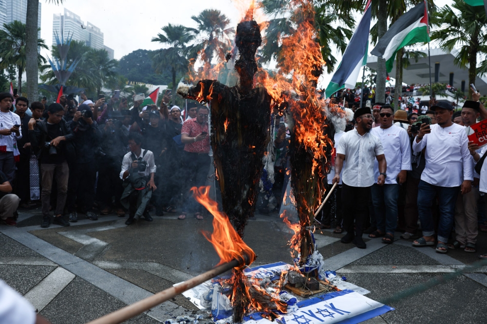 Two effigies draped in the Israeli flag are set ablaze amidst chants of ‘Hidup Palestin’ (long live Palestine) and ‘Hancur Zionist’ (crush the Zionists), outside Masjid Negara in Kuala Lumpur October 13, 2023. 