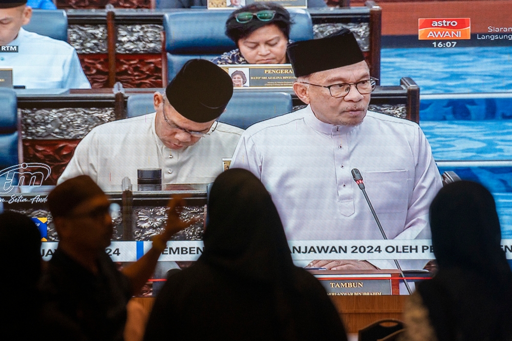 Government servants watching the live telecast of Finance Minister Datuk Seri Anwar Ibrahim speaking during the tabling of Budget 2024 in the Dewan Rakyat, October 13, 2023. — Picture by Shafwan Zaidon