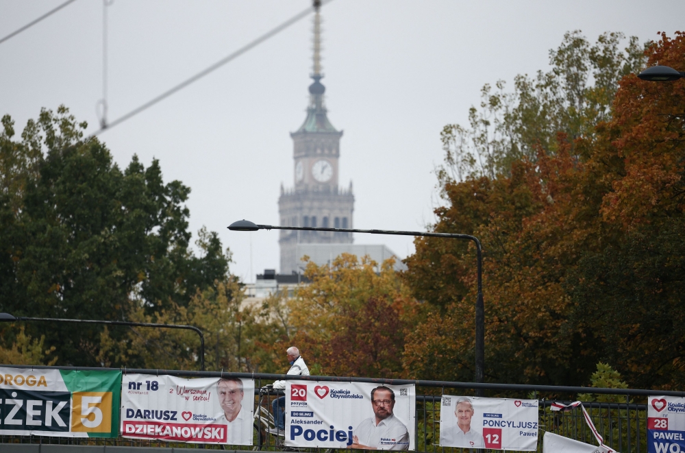 A man rides near election posters displayed in city centre, before Sunday’s parliamentary elections, in Warsaw, Poland October 13, 2023. — Reuters pic