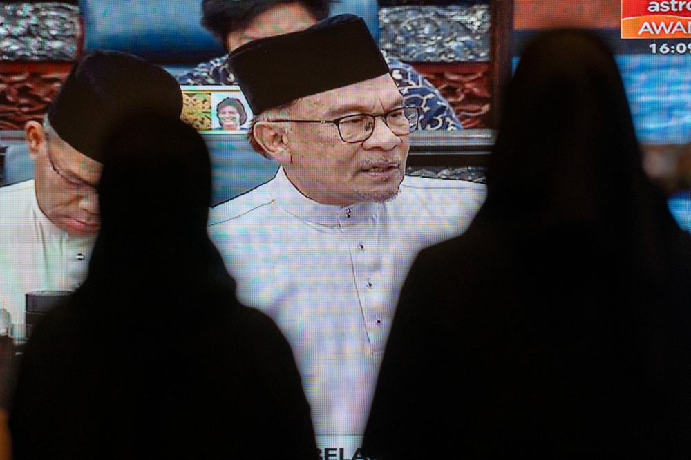 Government servants watch the live telecast of Finance Minister Datuk Seri Anwar Ibrahim speaking during the tabling of Budget 2024 in the Dewan Rakyat October 13, 2023. — Picture by Shafwan Zaidon
